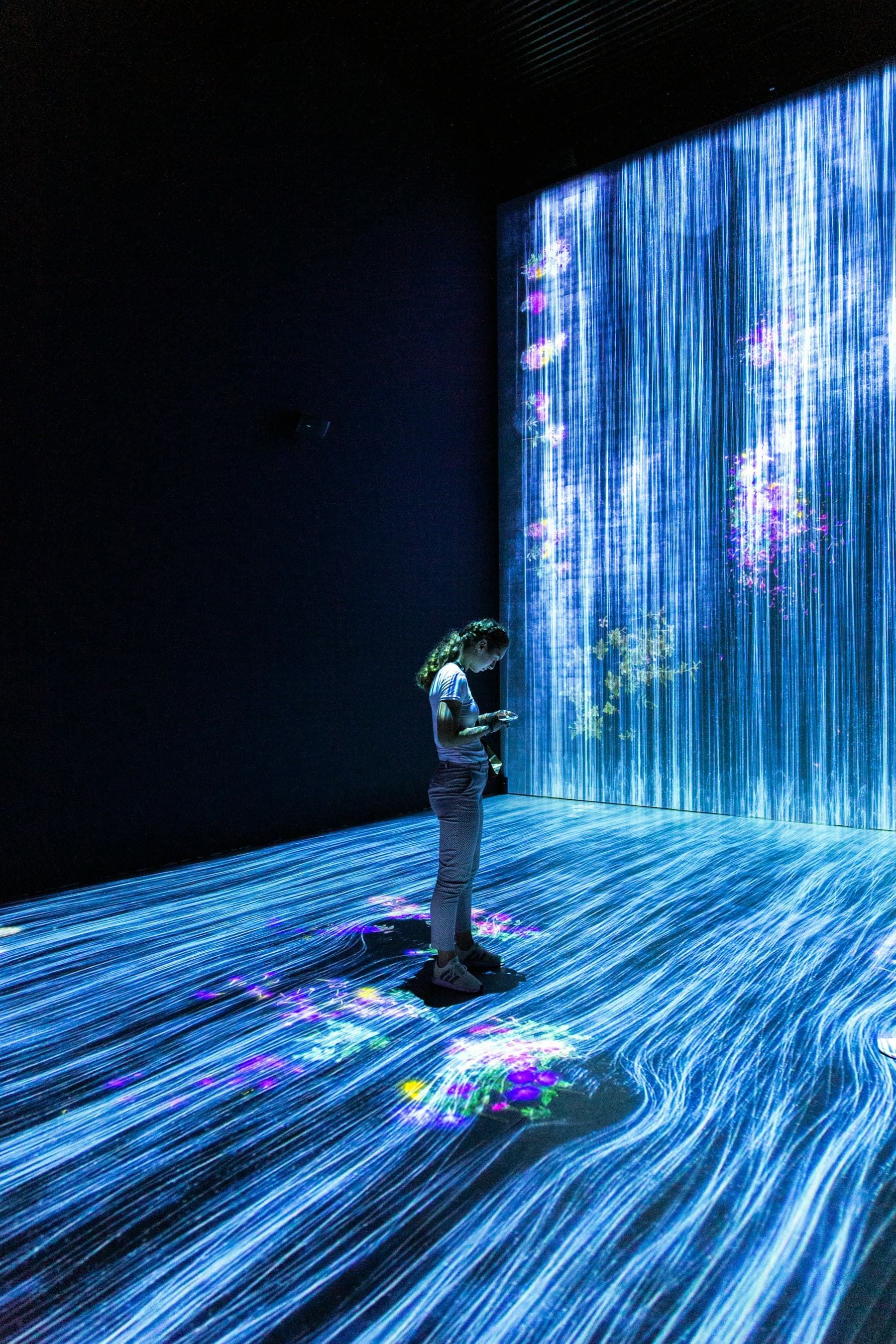 Person in an immersive digital light installation, the kind of media work the generative AI development life cycle covers